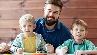 Vater mit zwei Kindern mit Stiften