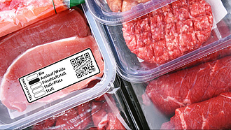 Verschiedene verpackte Fleischprodukte, davor beispielhaft das neue staatliche Tierhaltungskennzeichen